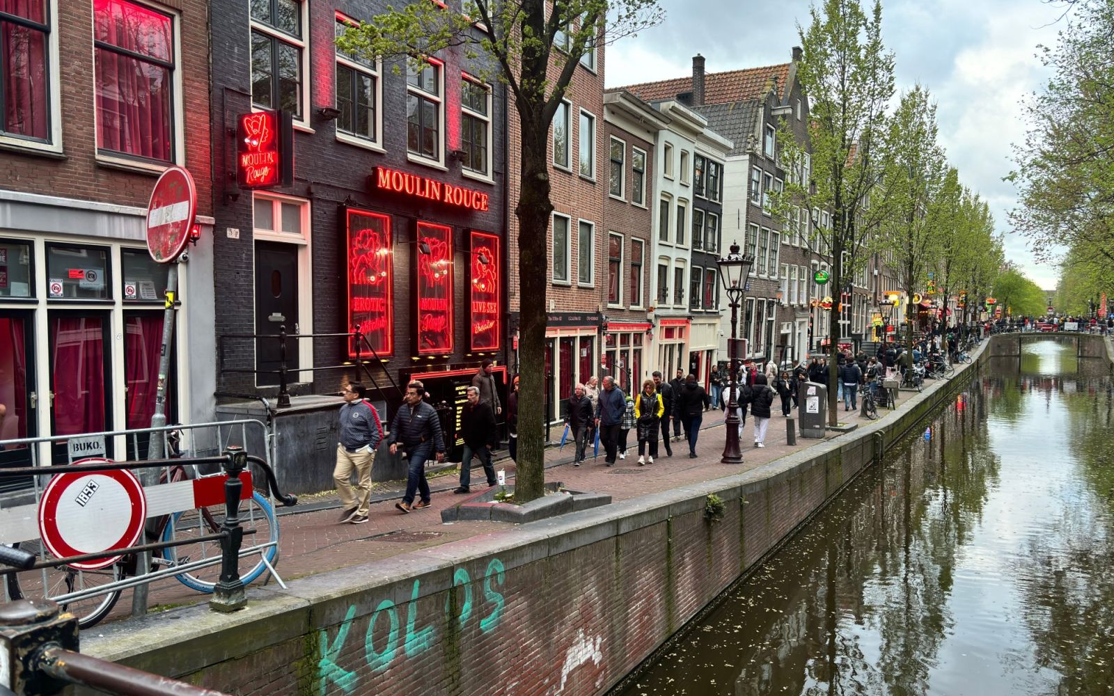 Gevel van Moulin Rouge aan de Oudezijds Achterburgwal, met rode neonlichtjes en de gracht